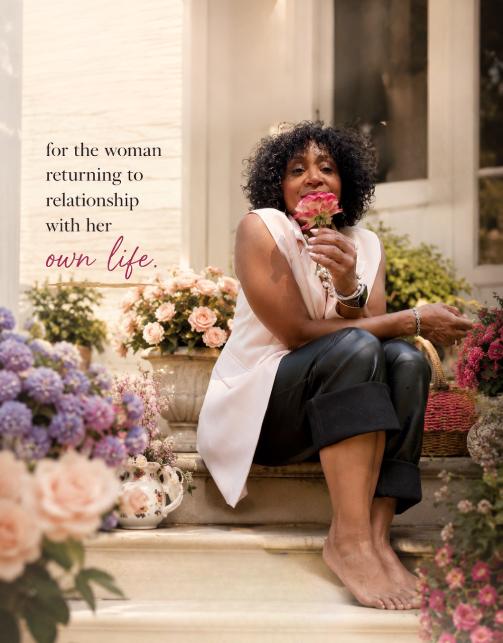 Quadia, founder of BLOOM, on a flower-lined stoop holding a rose